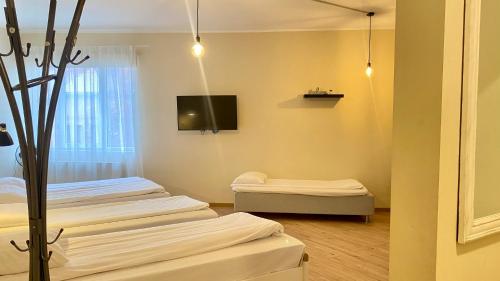 a room with two beds and a tv on the wall at Kastanimaja Apartments in Tartu