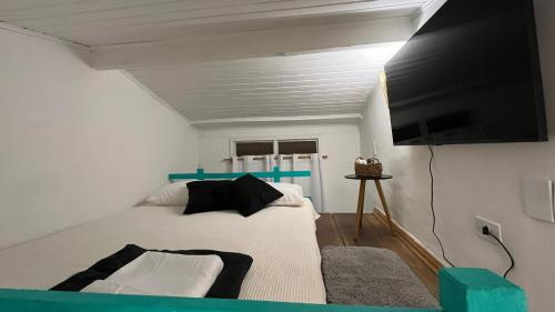 a bedroom with a bed and a flat screen tv at Mar & Ilha - Guest House - Praia de Maresias in São Sebastião