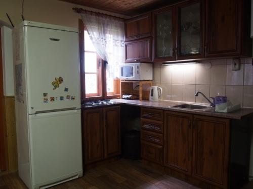 Una cocina con refrigerador blanco y gabinetes de madera. en Domeček Karlov, en Malá Morávka