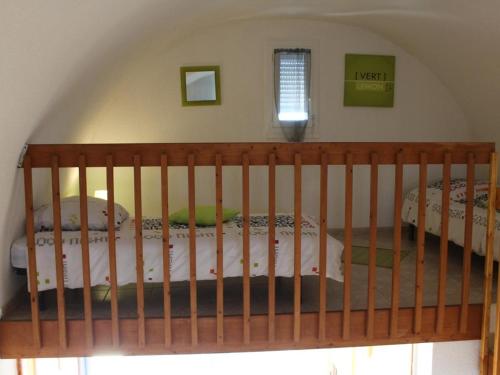 a crib in a bedroom with two beds at Appartement Gruissan, 1 pièce, 6 personnes - FR-1-229-65 in Gruissan