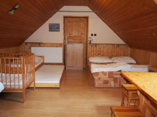 un dormitorio en el ático con 2 camas en una habitación en Domeček Karlov en Malá Morávka