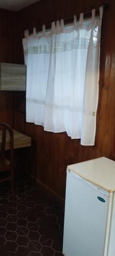une cuisine avec une fenêtre dotée d'un rideau blanc dans l'établissement Habitación c/baño gran ubicación, à San Juan