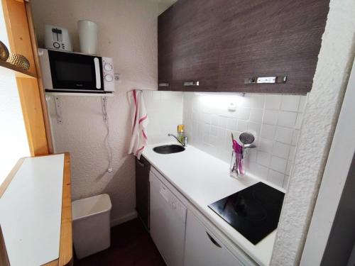 une petite cuisine avec un évier et un micro-ondes dans l'établissement Charmant studio au calme avec balcon et internet - FR-1-292-108, à Isola 2000