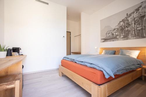 a bedroom with a bed and a painting on the wall at Locanda della Masseria a Porza, Lugano in Porza