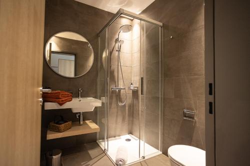 ein Bad mit einer Dusche, einem Waschbecken und einem Spiegel in der Unterkunft Locanda della Masseria in Porza