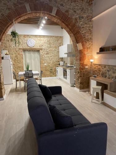 a living room with a black couch and a kitchen at La Casina del Corso in Massa Marittima