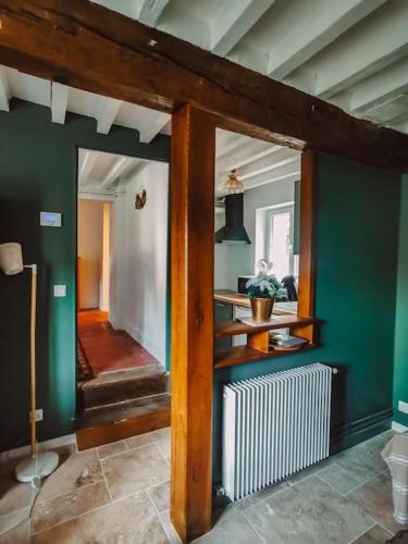 a living room with green walls and a white radiator at Le val en chêne in Choisy-au-Bac