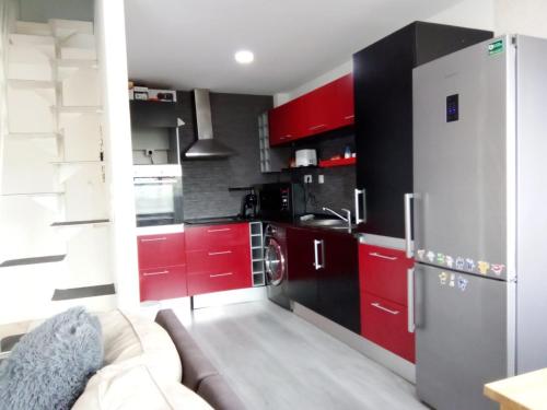 uma cozinha com armários vermelhos e um frigorífico de aço inoxidável em Miramar on Beach View Villa em Vila Nova de Gaia