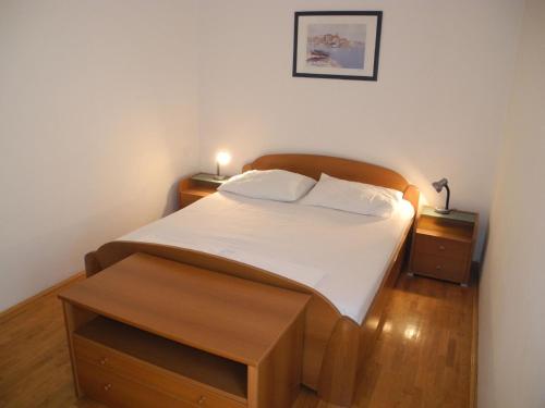 - une chambre avec un grand lit et une tête de lit en bois dans l'établissement Ferienwohnung für 5 Personen in Dramalj, Kvarner Bucht, à Dramalj