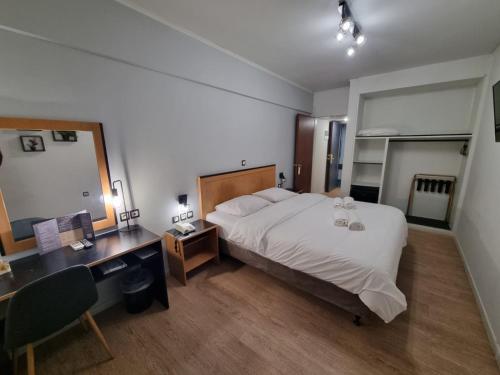 a hotel room with a bed and a desk and a desk at Savoy Hotel in Piraeus
