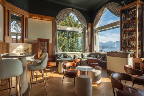 a restaurant with large windows and tables and chairs at Art Deco Hotel Montana Luzern in Luzern