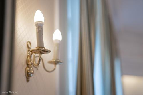 a light on a wall with two candles on it at Schlosshotel Westerholt in Herten