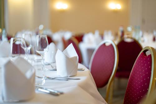 a dining room with tables and chairs with wine glasses at Schlosshotel Westerholt in Herten
