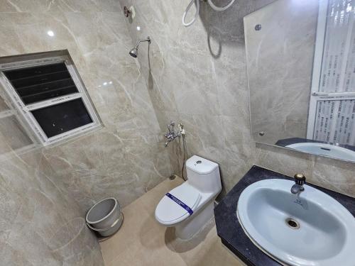 a bathroom with a sink and a toilet at HOTEL MERILIN in Erode