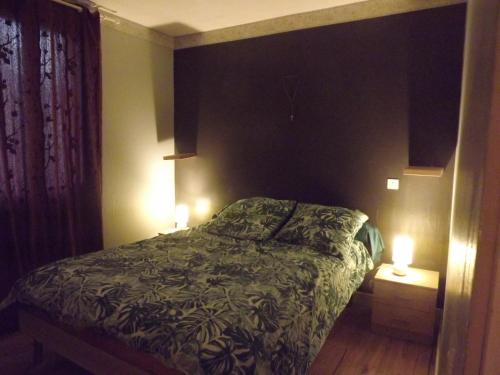 - une chambre avec un lit et deux lumières allumées dans l'établissement Bienvenue à La Noyeraie, à Bio