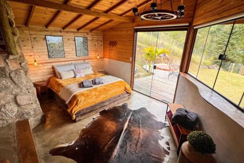 a bedroom with a bed in a log cabin at Cabana Lobo Guará in São Bento do Sapucaí
