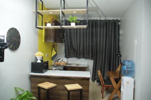 a kitchen with a sink and a counter with stools at Enn lovely apartment 11 in Bungoma