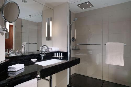 La salle de bains est pourvue d'un lavabo et d'une douche. dans l'établissement Berlin Marriott Hotel, à Berlin