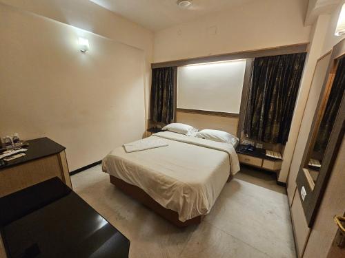 a hotel room with a bed and a window at HOTEL MERILIN in Erode