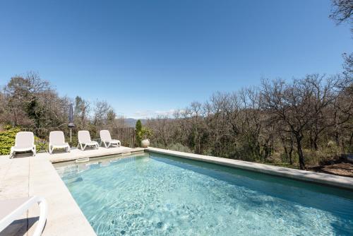 a swimming pool with chairs and a swimming pool at La Bastide des Milles in Apt