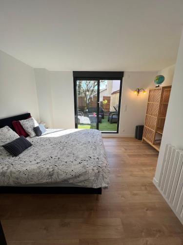 une chambre blanche avec un lit et une grande fenêtre dans l'établissement Secret Garden, à Ay