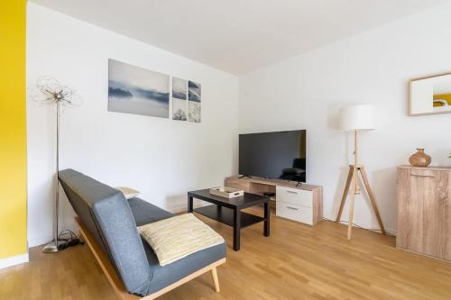 a living room with a couch and a tv at Élégant Appartement Familial Disneyland & Gare RER in Bussy-Saint-Georges