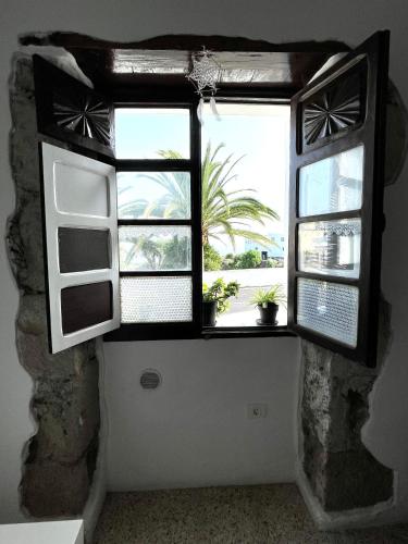 a room with a window with plants in it at El Hostal del Cubo in San Juan de la Rambla