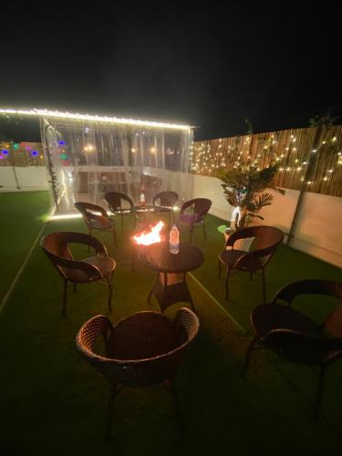 a group of chairs and a table with a fire at BoozyRoofs in New Delhi