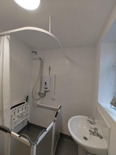 uma casa de banho branca com um lavatório e um chuveiro em Anstuns LODGE em Liverpool
