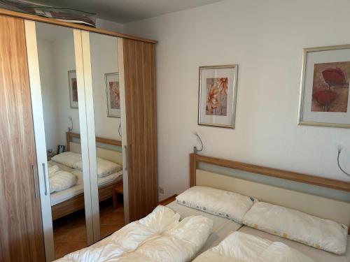 1 dormitorio con espejo y 1 cama. en Küstenbude Ostseeblick, en Grömitz