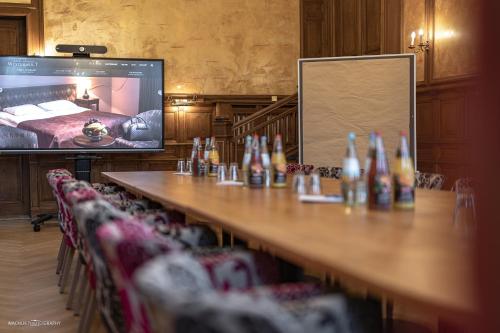 a conference room with a long table and a projection screen at Schlosshotel Westerholt in Herten