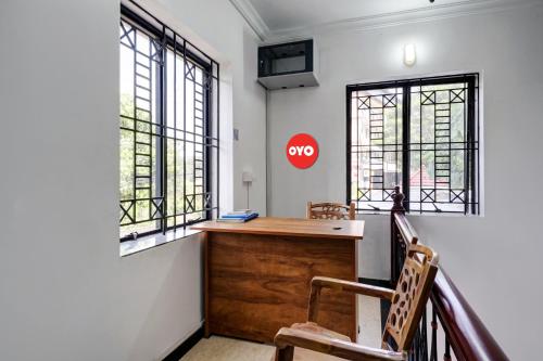 - un bureau dans une pièce dotée de fenêtres et d'un panneau d'arrêt dans l'établissement OYO Kakkanad Heights Inn, à Kakkanad