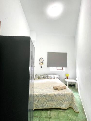 a bedroom with a bed and a tv on the wall at El Hostal del Cubo in San Juan de la Rambla