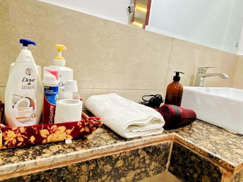 um balcão de casa de banho com um lavatório e produtos de higiene pessoal em Gold crest Mall, The Aesthetic one bed suite em Lahore