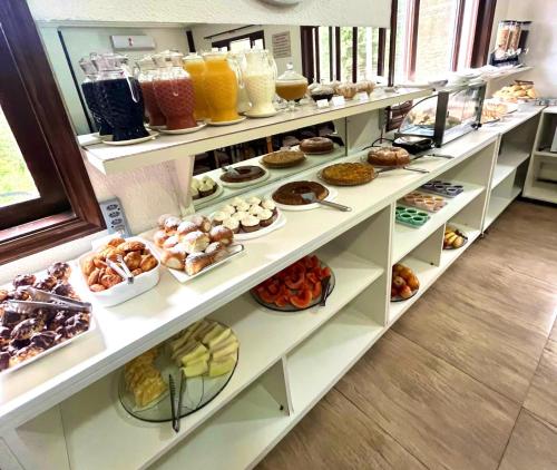 a bakery with shelves filled with different types of pastries at Pousada Primavera Campos do Jordao in Campos do Jordão