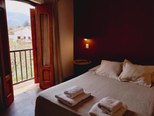 a bedroom with a bed with two towels on it at Hotel REAL CAFAYATE in Cafayate