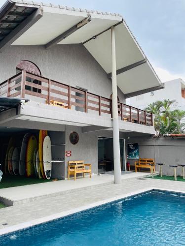 a house with a swimming pool and a balcony at Surf'O Hostel in Rio de Janeiro
