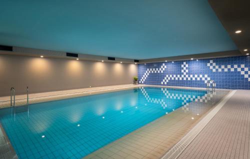 a large swimming pool with a blue light in a building at Abacco by Rilano in Korntal-Münchingen