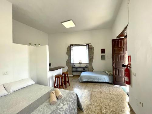 a bedroom with two beds and a desk in it at El Hostal del Cubo in San Juan de la Rambla