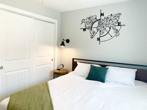 a bedroom with a white bed and a clock on the wall at Modern Townhouse in Tempe Near Arizona State University with Fast Wi-Fi & Free Parking for Cozy Stay in Tempe