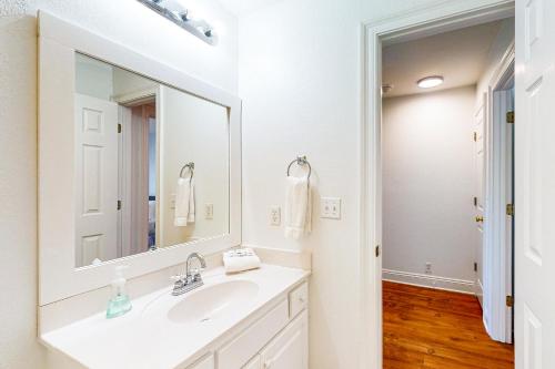 a white bathroom with a sink and a mirror at The Red Rocker in Highland View