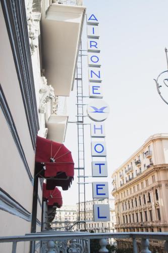 a sign for a hotel with a red umbrella at Airone Hotel in Naples