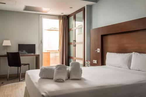 Säng eller sängar i ett rum på Hotel Madanis Liceo