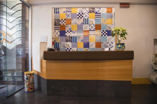 a lobby with a counter with a tile wall at Airone Hotel in Naples