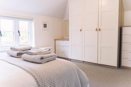 a bedroom with a bed with towels on top of it at Contemporary mid-terrace cottage in Priors Marston