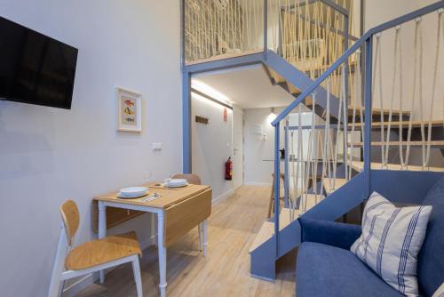 una sala de estar con una escalera azul y un escritorio en FLORIT FLATS - The Mediterraneo Apartments, en Valencia