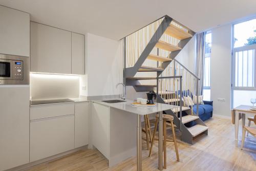 una cocina con armarios blancos y una escalera de caracol en FLORIT FLATS - The Mediterraneo Apartments, en Valencia