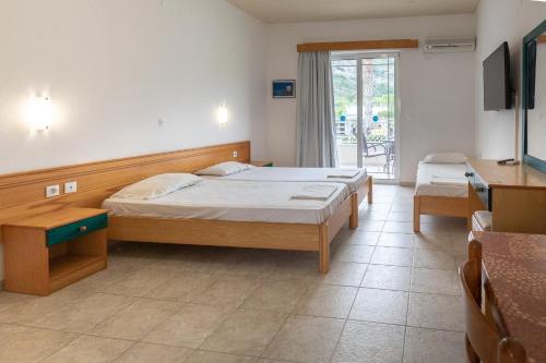 1 dormitorio con 2 camas, escritorio y TV en Faliraki Dream Apartment 3 en Kallithea Rhodes