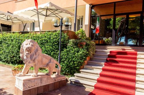 una estatua de un león frente a un edificio con una alfombra roja en Hotel & Residence Venezia 2000, en Lido de Venecia