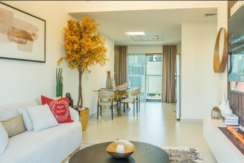 een woonkamer met een bank en een tafel bij Autumn Falls, 2 Bedroom full service equipped appartement in Dubai